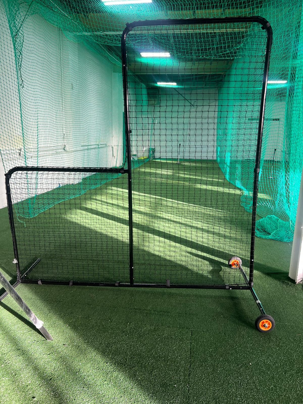 Wheeled L-shaped protective screen positioned in a practice lane
